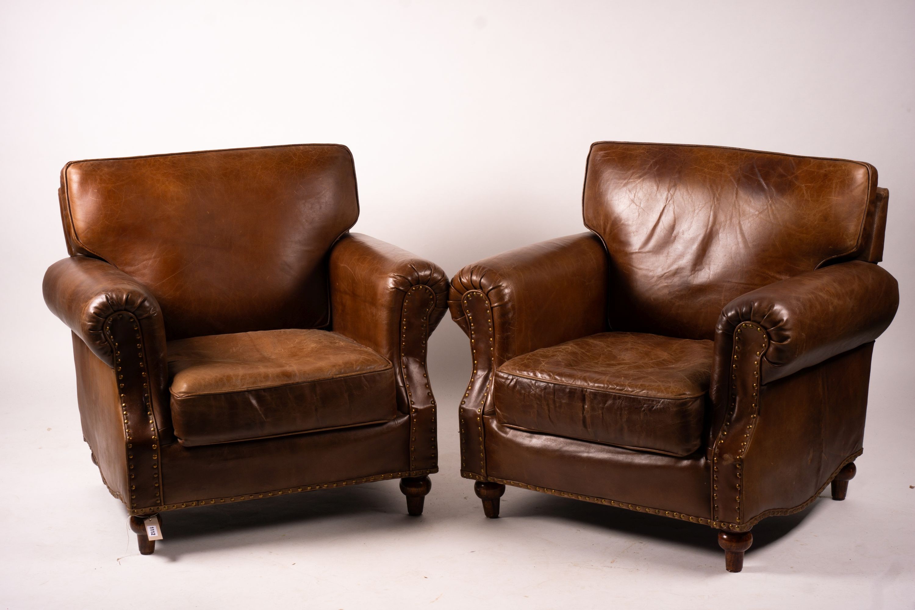 A pair of brown leather club armchairs, width 96cm, depth 80cm, height 90cm